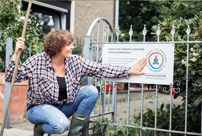 Stefanie Wallendschus vor dem Praxisschild